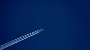 jet plane and trail across a dark blue sky